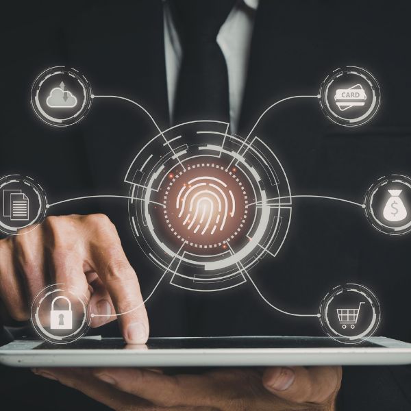 A business professional interacting with a tablet, surrounded by digital icons related to cybersecurity and financial transactions, highlighted by a fingerprint symbol at the center.