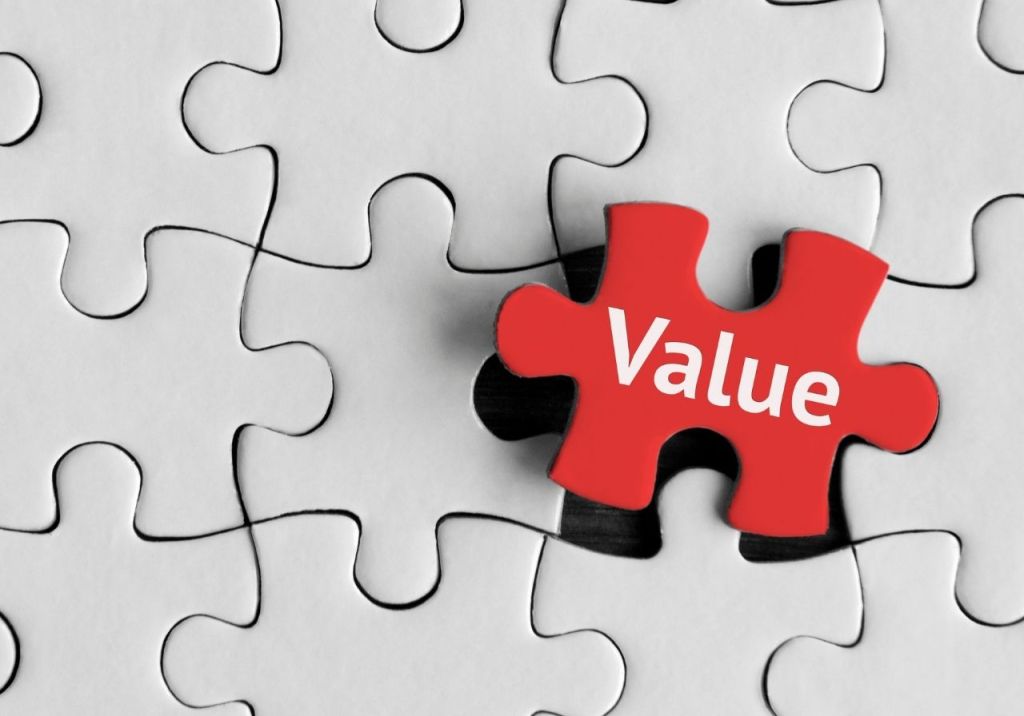 A red puzzle piece with the word 'Value' is being placed into a predominantly white puzzle.