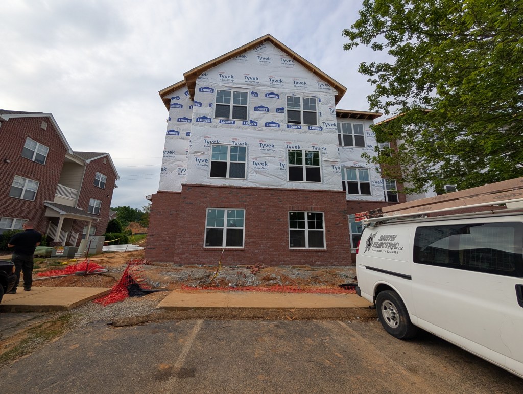 apartment exterior under construction with new wrap around it 