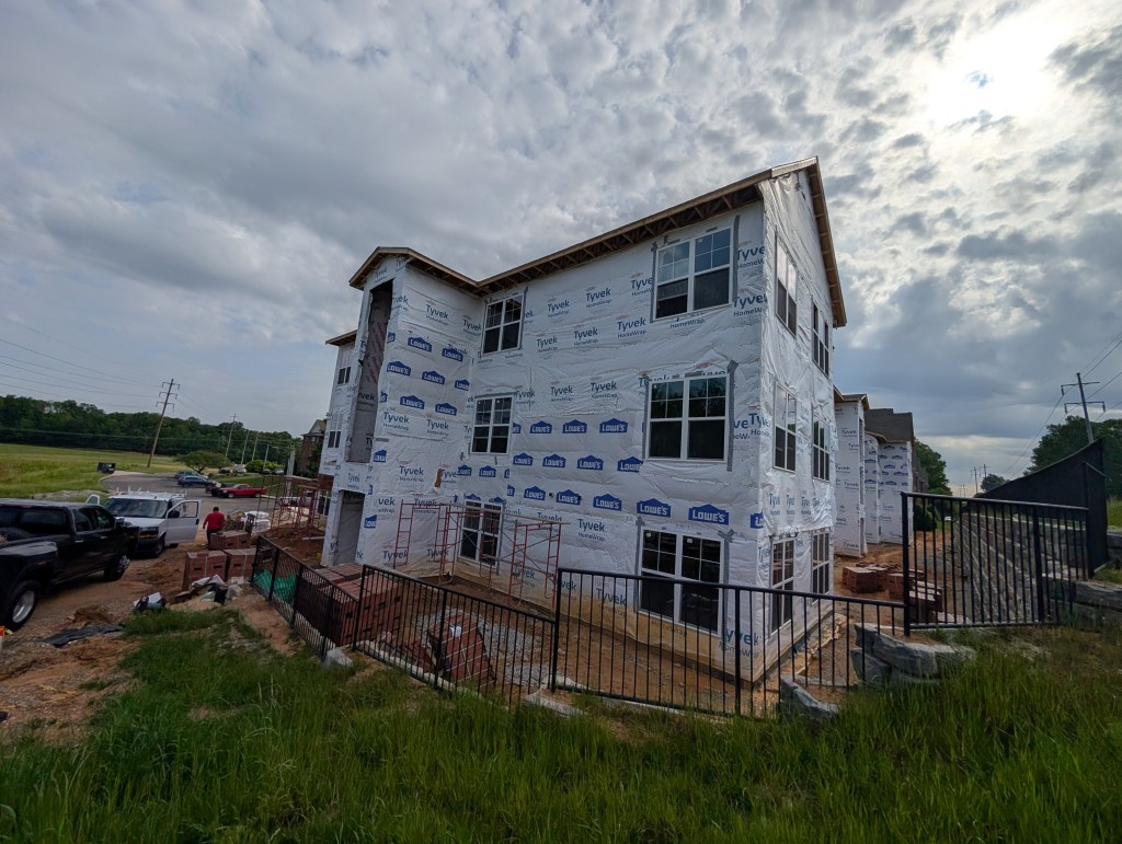 apartment exterior under construction with new wrap around it 