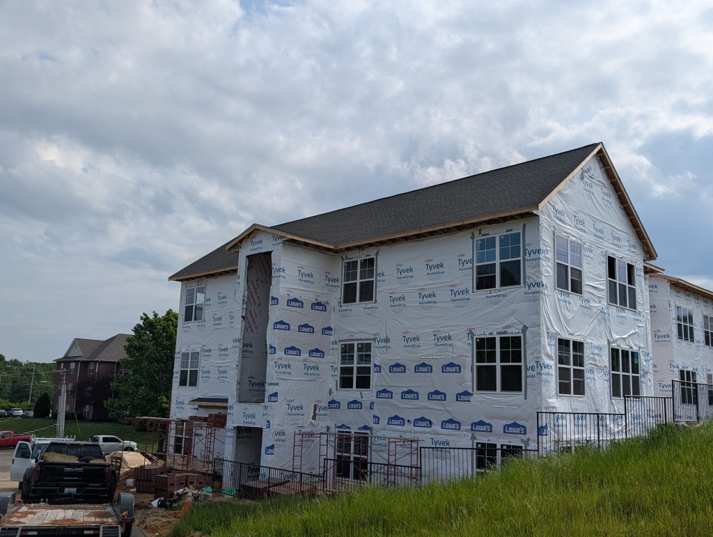 apartment exterior under construction with new wrap around it 