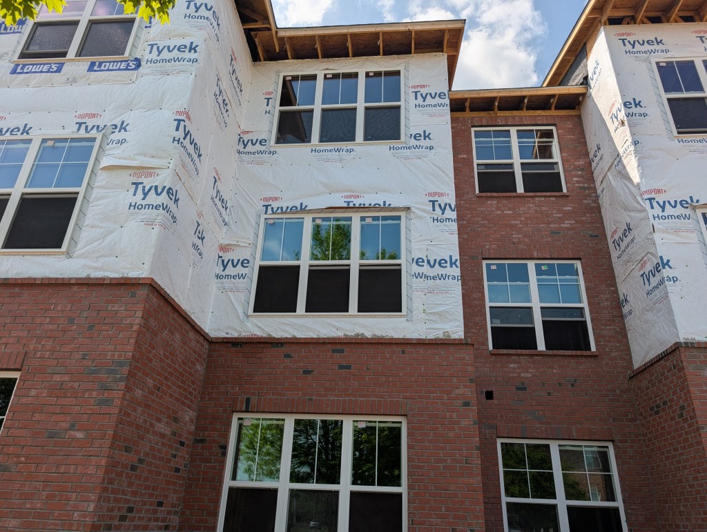 apartment exterior under construction with new wrap around it 